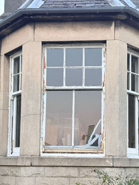 Portobello bay window before restoration, with peeling paint and original glazing.